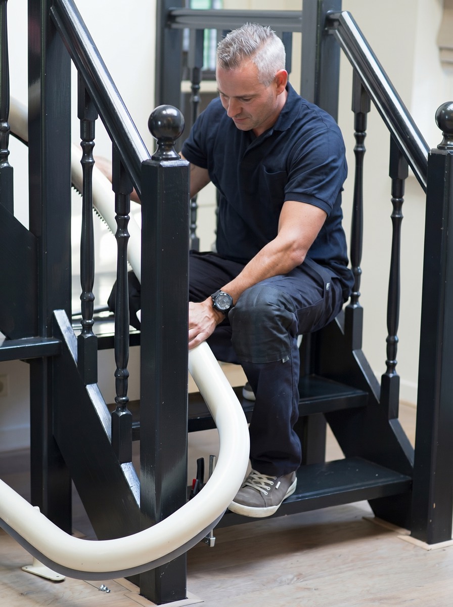 A vetted local stairlift installer in workwear (illustrative; image intentionally blurred — no specific installer is named or shown)